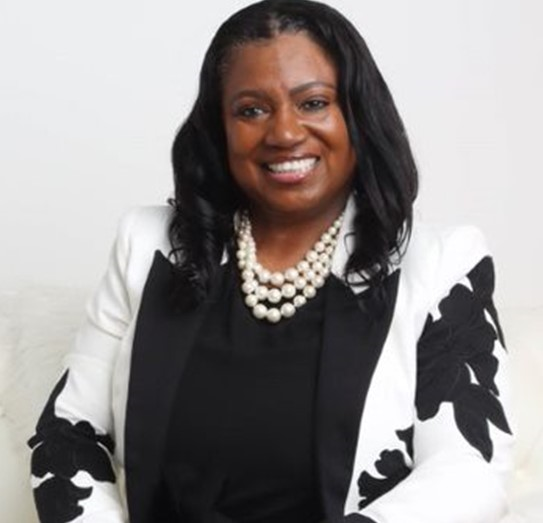 Confident woman in a stylish black and white outfit with a pearl necklace.