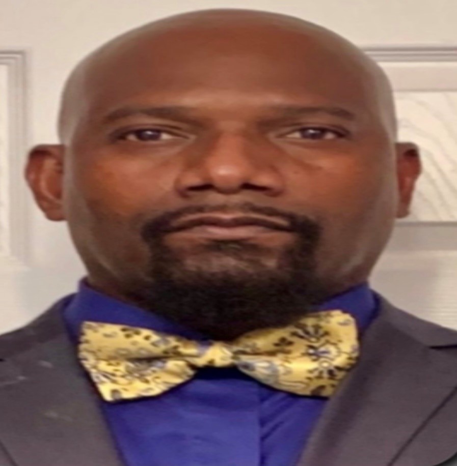 Portrait of a man wearing a suit and a patterned bow tie.