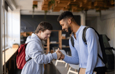 Mentor greeting young student with handshake in youth program setting