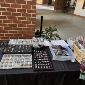 Table displaying various collectible stamps and small items for sale.