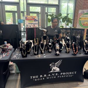 Vendor showcasing jewelry at The Bead Project booth.