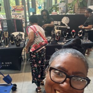 People shopping for jewelry at a market stall.